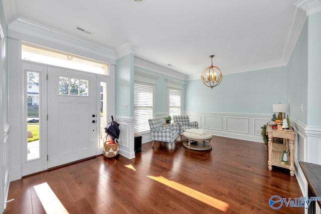 entryway featuring dark hardwood / wood-style flooring, crown molding, and an inviting chandelier