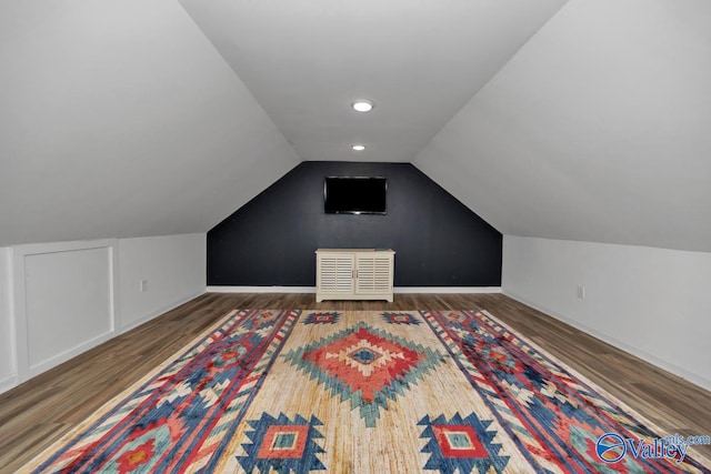 bonus room with dark hardwood / wood-style flooring and vaulted ceiling