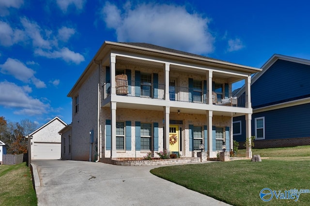 view of front of house with an outbuilding, a balcony, a garage, and a front lawn