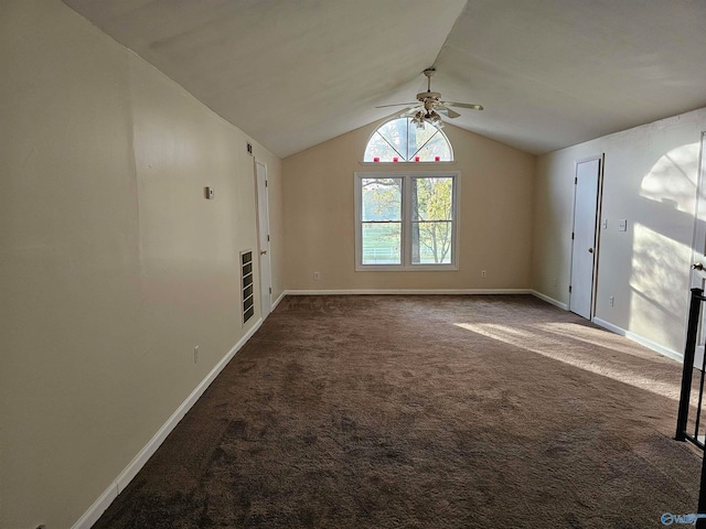 interior space with ceiling fan, dark carpet, and vaulted ceiling