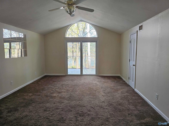 spare room featuring ceiling fan, dark carpet, and lofted ceiling