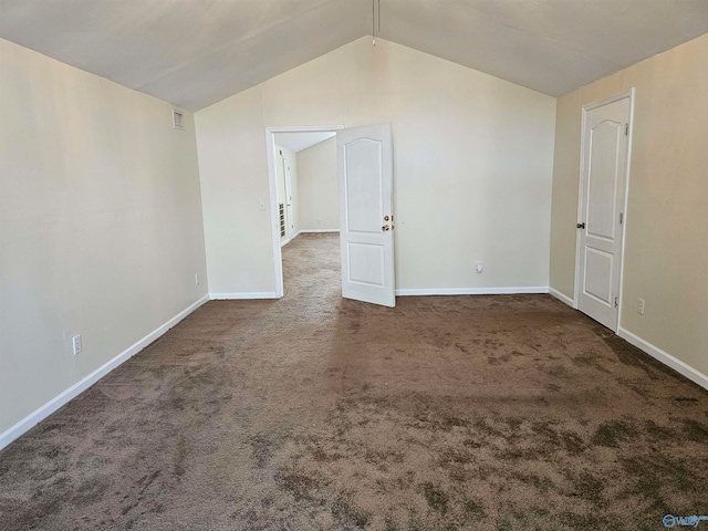 empty room featuring dark carpet and vaulted ceiling