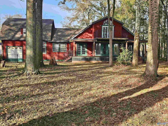 back of house featuring a garage and an outbuilding