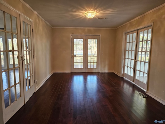 spare room featuring french doors, dark wood-type flooring, and ornamental molding