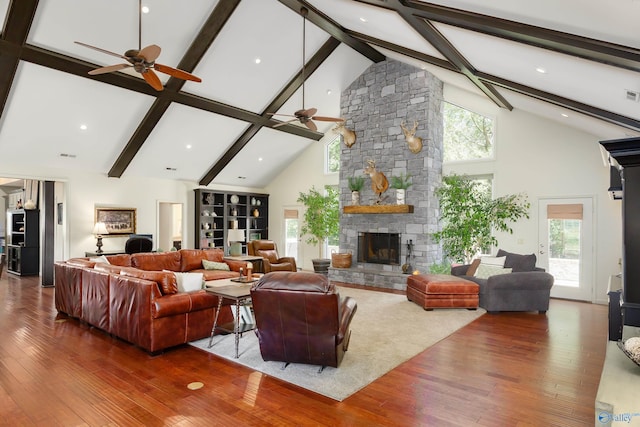 living room featuring wood-type flooring, beamed ceiling, a fireplace, high vaulted ceiling, and ceiling fan