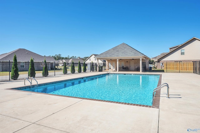 view of swimming pool with ceiling fan and a patio