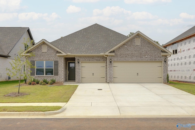 view of front facade with brick siding, a front lawn, an attached garage, and a shingled roof