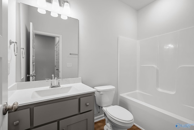 full bathroom with hardwood / wood-style flooring, vanity, shower / bath combination, and toilet