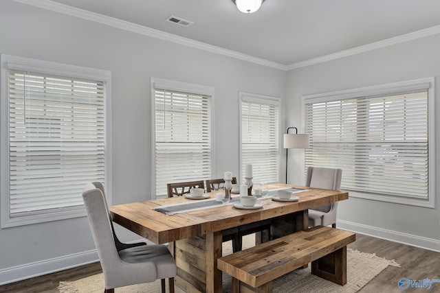 dining area featuring dark wood-type flooring and crown molding