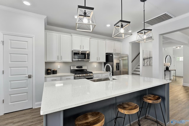 kitchen featuring stainless steel appliances, a large island, pendant lighting, and white cabinets