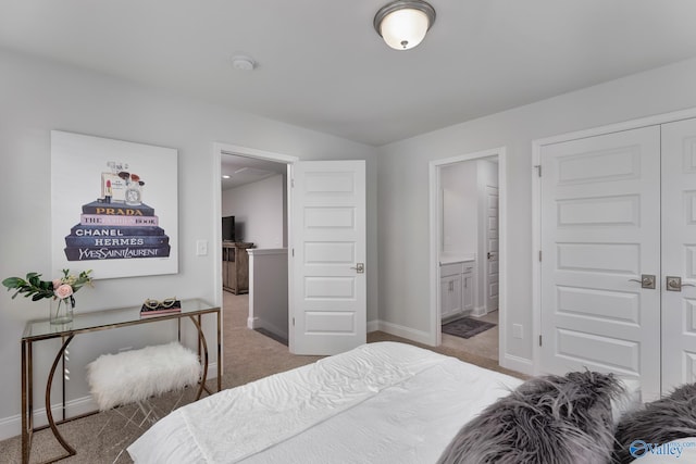 carpeted bedroom with ensuite bath and a closet