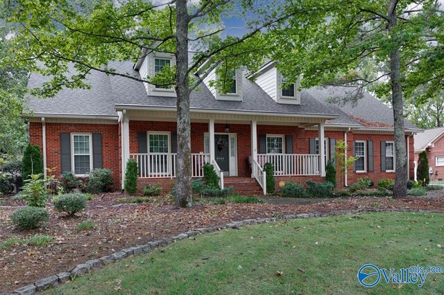 cape cod-style house featuring a front lawn and a porch