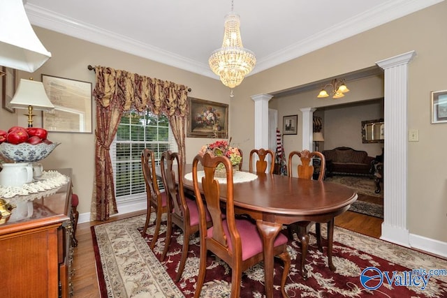 dining space featuring wood-type flooring, a chandelier, decorative columns, and crown molding