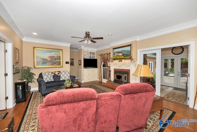 living room featuring ceiling fan, ornamental molding, a brick fireplace, french doors, and hardwood / wood-style floors