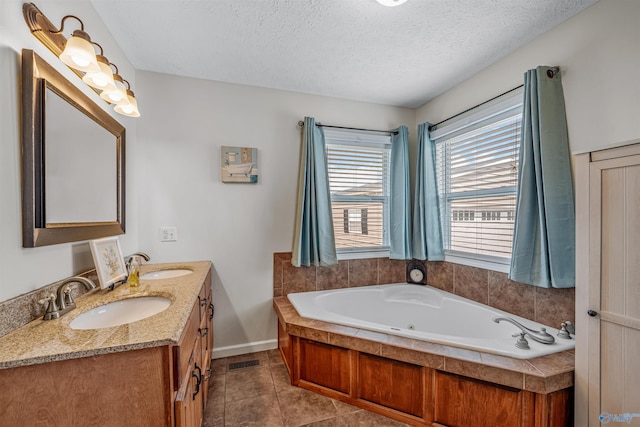 bathroom with visible vents, a textured ceiling, a sink, and tile patterned floors