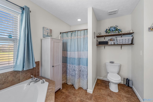 full bath featuring a garden tub, a textured ceiling, visible vents, and toilet