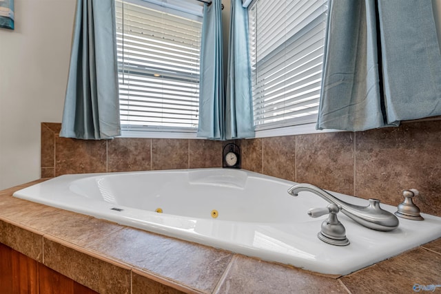 bathroom with a jetted tub and a wealth of natural light