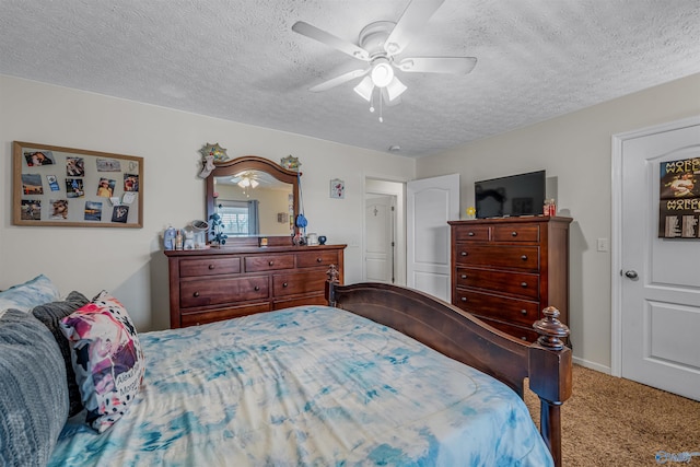 bedroom with a ceiling fan, carpet floors, and a textured ceiling