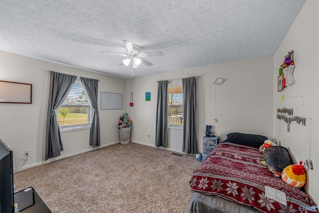 carpeted bedroom with a ceiling fan, baseboards, and a textured ceiling