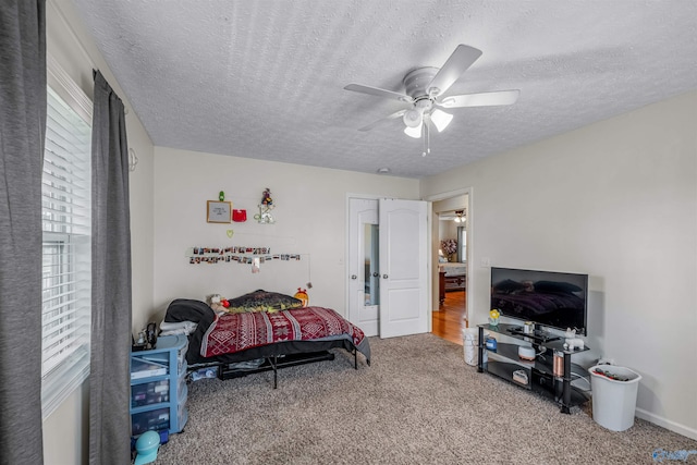carpeted bedroom featuring a ceiling fan and a textured ceiling