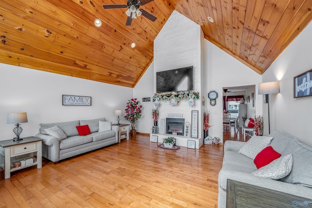 living room with wooden ceiling, high vaulted ceiling, a ceiling fan, a fireplace, and wood finished floors