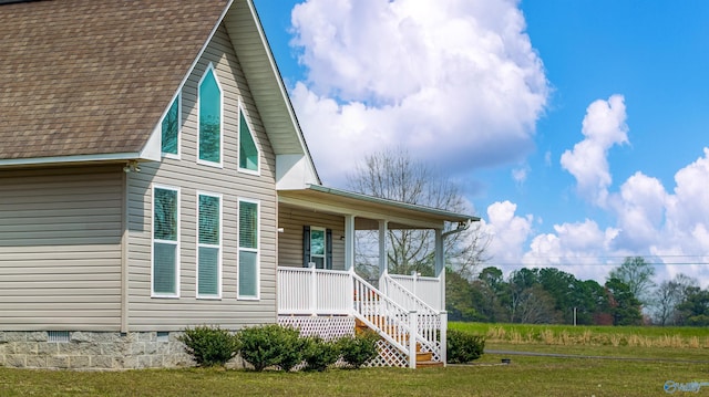 exterior space featuring crawl space, a shingled roof, covered porch, and a lawn
