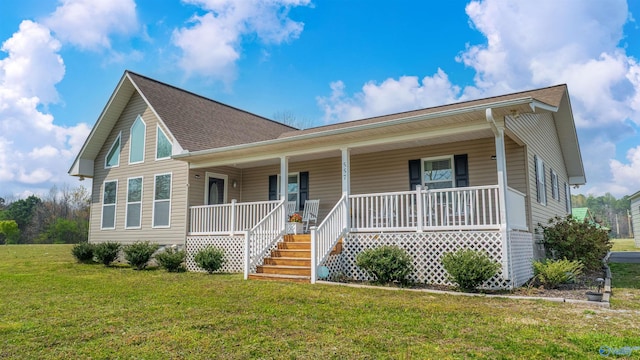 view of front of property featuring covered porch, roof with shingles, and a front yard