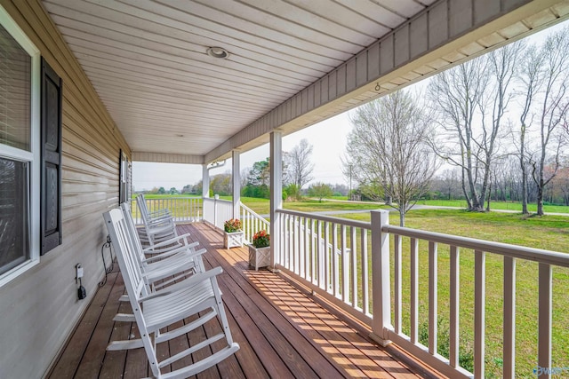 deck featuring covered porch and a yard