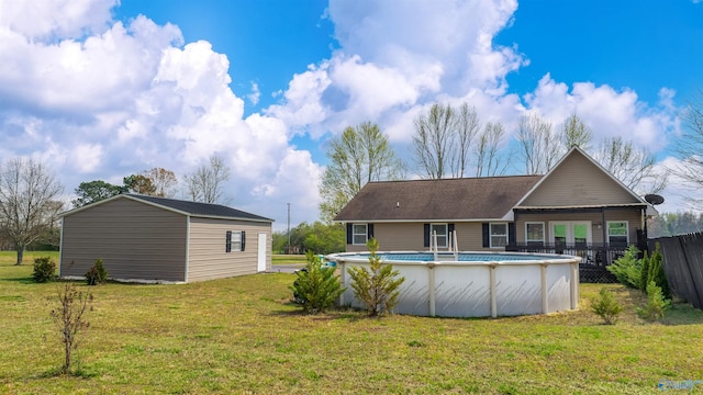 rear view of property featuring a fenced in pool, fence, and a lawn