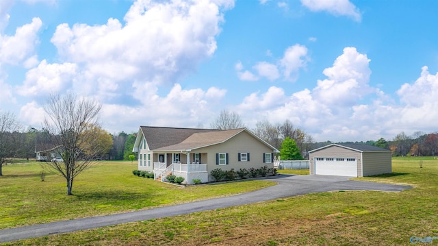 ranch-style house featuring a front lawn, covered porch, an outdoor structure, and a garage