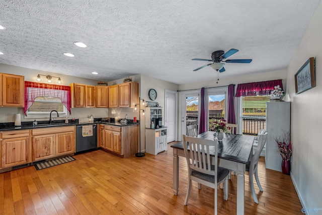 kitchen featuring ceiling fan, light wood-style flooring, dishwashing machine, and dark countertops