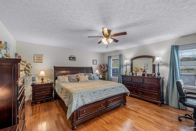bedroom featuring a textured ceiling, a ceiling fan, and light wood-type flooring