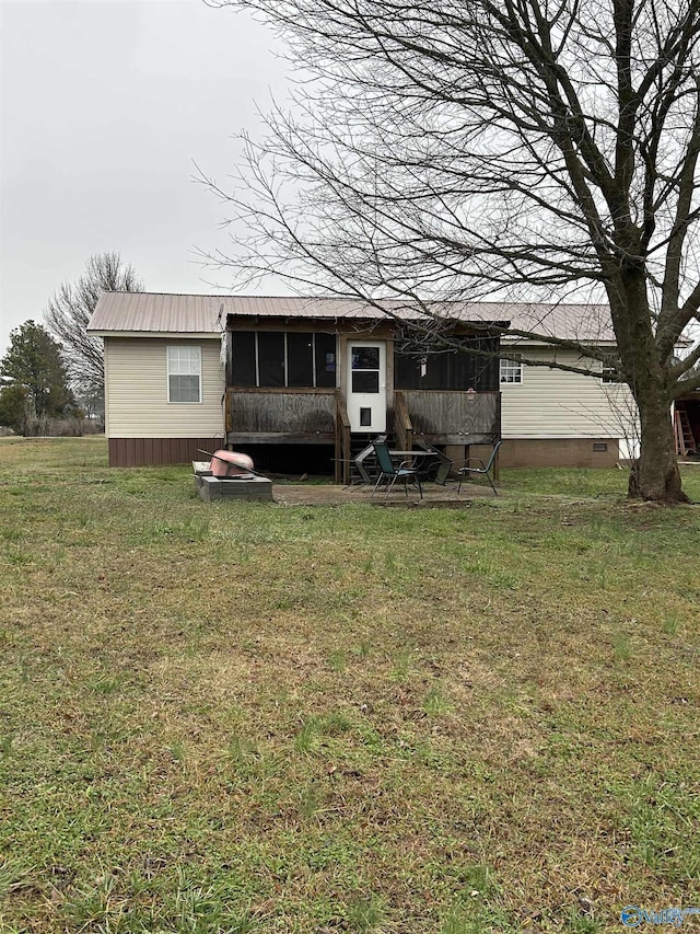 back of house featuring a sunroom and a lawn