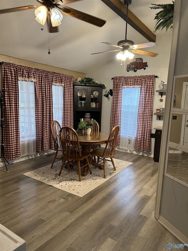 dining space featuring a textured ceiling, lofted ceiling with beams, dark hardwood / wood-style floors, and ceiling fan