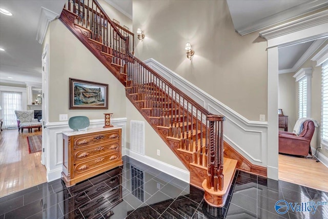 stairs featuring a decorative wall, recessed lighting, wainscoting, and ornamental molding