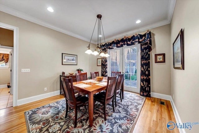 dining room with light wood-style floors, baseboards, and ornamental molding