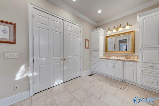 bathroom featuring vanity, crown molding, and baseboards