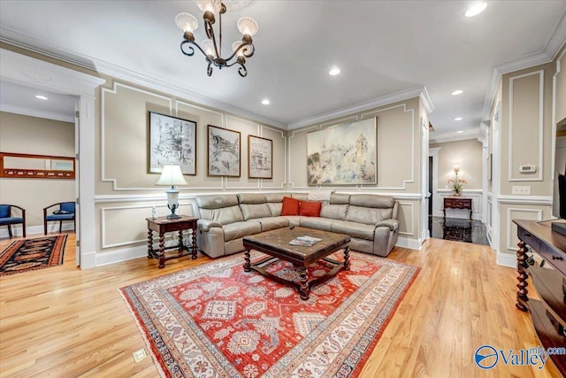 living room with light wood finished floors, a decorative wall, recessed lighting, and crown molding