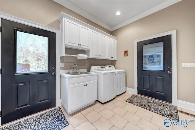 washroom featuring ornamental molding, a sink, washer and dryer, cabinet space, and baseboards