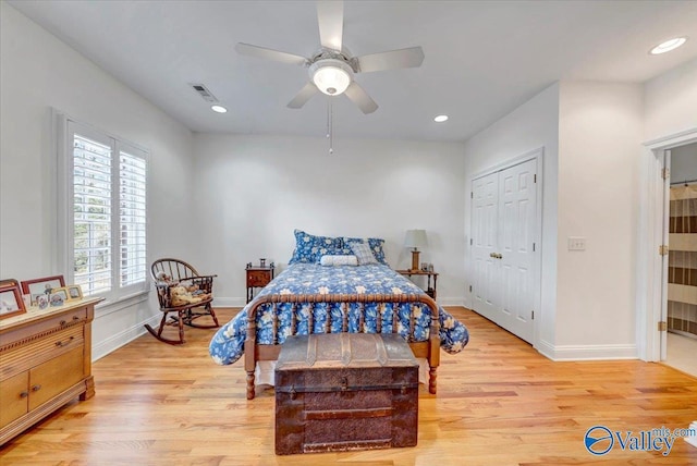 bedroom with visible vents, baseboards, and light wood finished floors