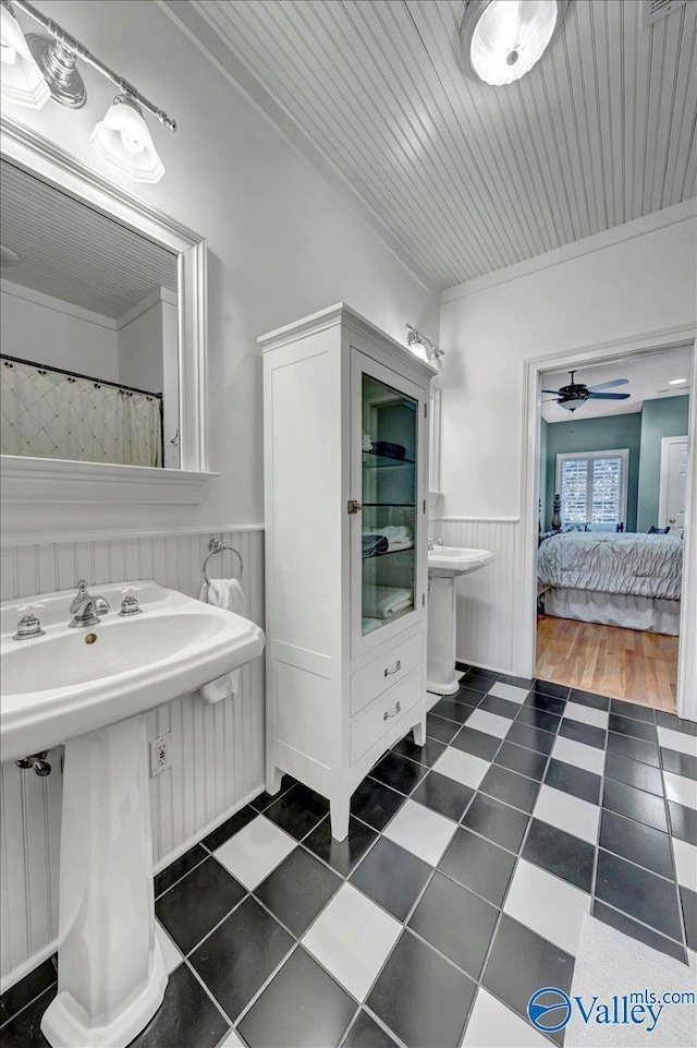 full bathroom featuring ceiling fan, a wainscoted wall, wooden ceiling, ensuite bath, and a sink