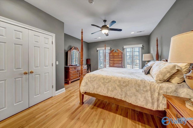 bedroom with light wood finished floors, visible vents, baseboards, a closet, and a ceiling fan