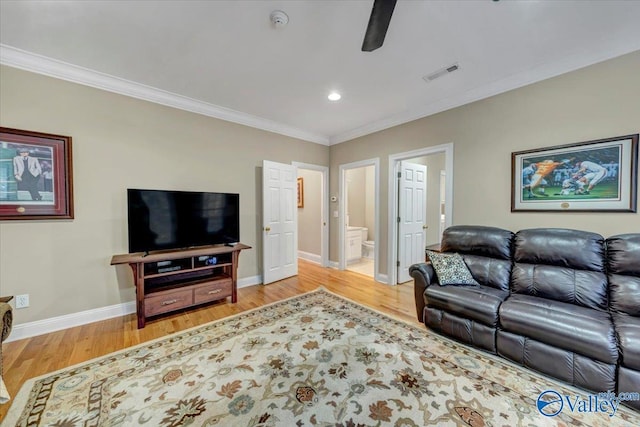 living area with visible vents, baseboards, ornamental molding, and light wood finished floors