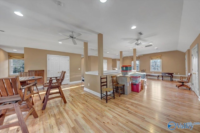 kitchen with visible vents, light wood finished floors, a peninsula, recessed lighting, and a kitchen bar