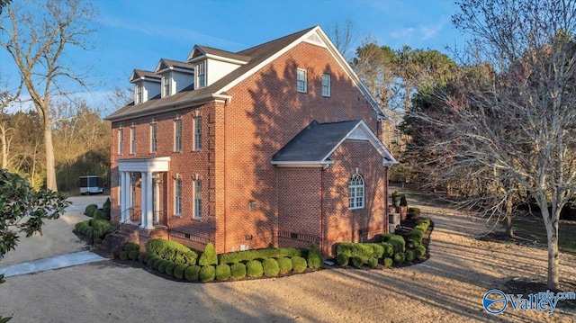 view of side of home featuring crawl space and brick siding