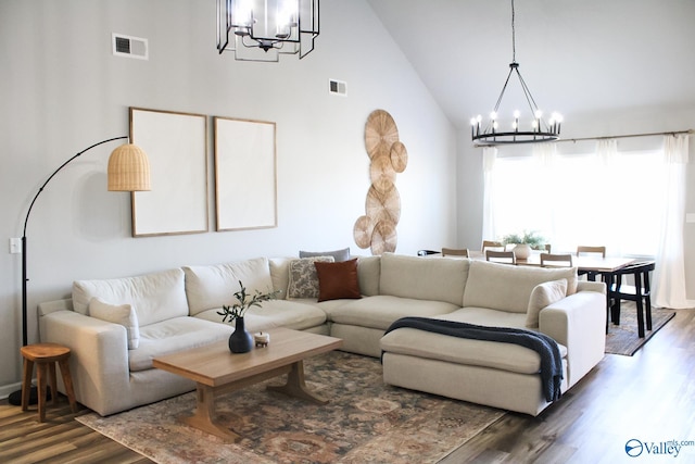 living room with high vaulted ceiling, a notable chandelier, and dark wood-type flooring