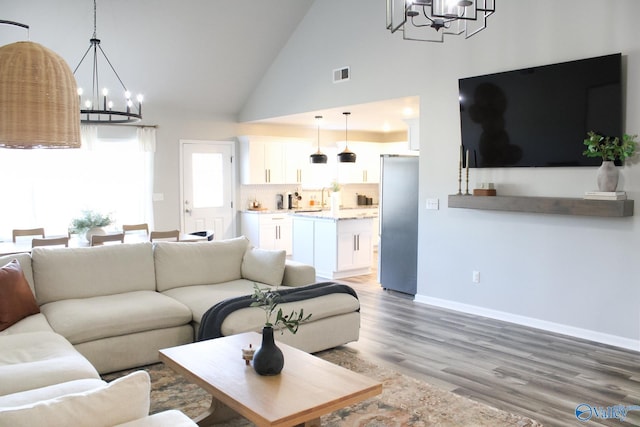 living room featuring high vaulted ceiling and hardwood / wood-style floors