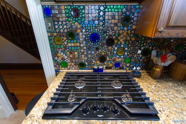 room details featuring light stone countertops, black gas cooktop, and hardwood / wood-style floors