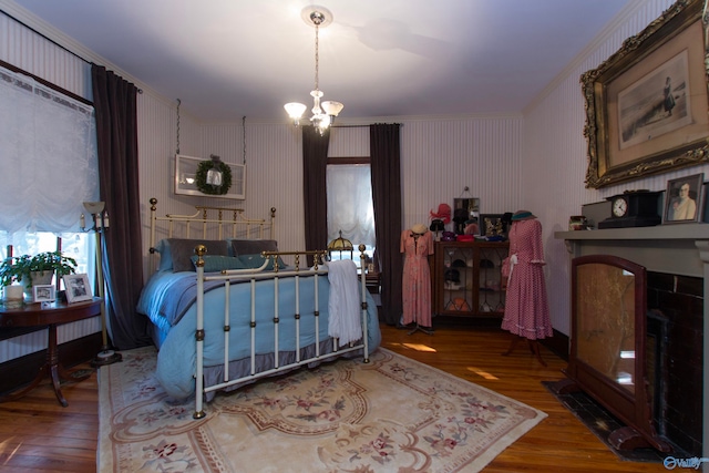 bedroom with crown molding, hardwood / wood-style flooring, and an inviting chandelier