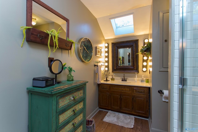 bathroom featuring vanity, lofted ceiling with skylight, and hardwood / wood-style flooring